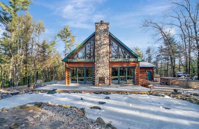 snow covered house featuring a wooden deck