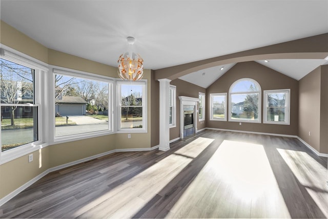 unfurnished living room with lofted ceiling, ornate columns, light hardwood / wood-style flooring, and an inviting chandelier