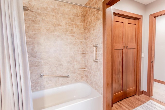 bathroom with hardwood / wood-style flooring and shower / tub combo with curtain