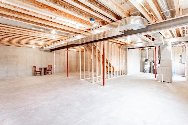 basement featuring water heater, electric panel, and heating unit