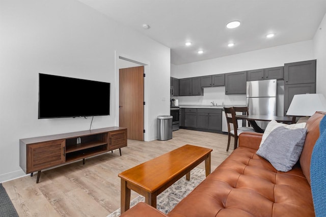 living room featuring sink and light hardwood / wood-style floors