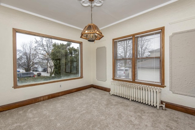 carpeted spare room with radiator heating unit and a notable chandelier