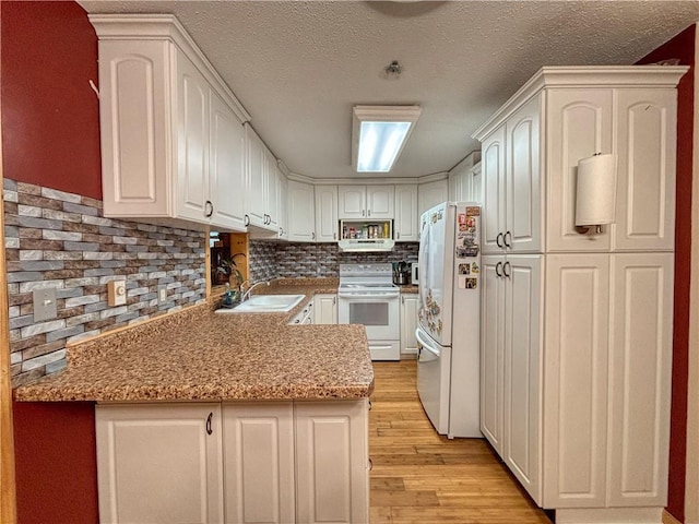 kitchen featuring light stone countertops, white appliances, sink, light hardwood / wood-style flooring, and white cabinetry