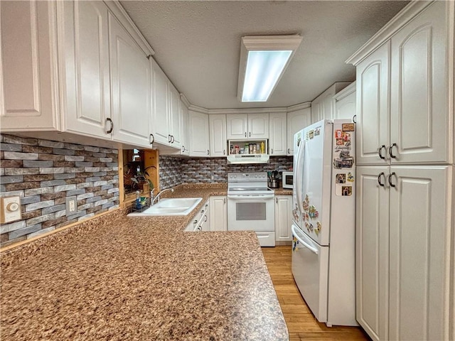 kitchen featuring white appliances, backsplash, sink, light wood-type flooring, and white cabinetry