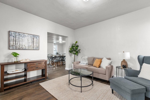 living room featuring a textured ceiling and dark hardwood / wood-style floors