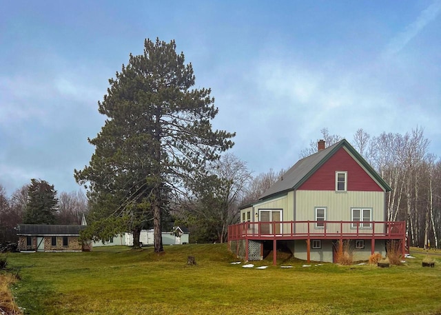 rear view of property featuring a lawn and a wooden deck