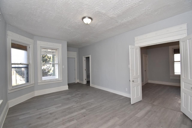 unfurnished room with wood-type flooring and a textured ceiling