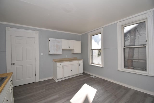 kitchen with white cabinetry, crown molding, and dark wood-type flooring