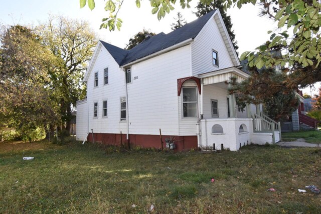 view of side of home with a yard