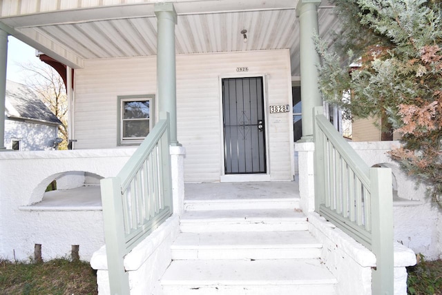 view of exterior entry featuring covered porch