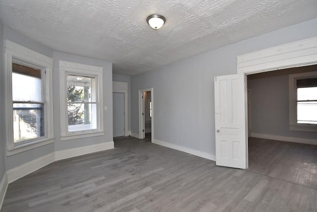 unfurnished room featuring hardwood / wood-style floors and a textured ceiling