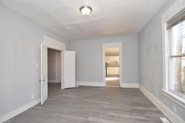 spare room with hardwood / wood-style floors and a textured ceiling