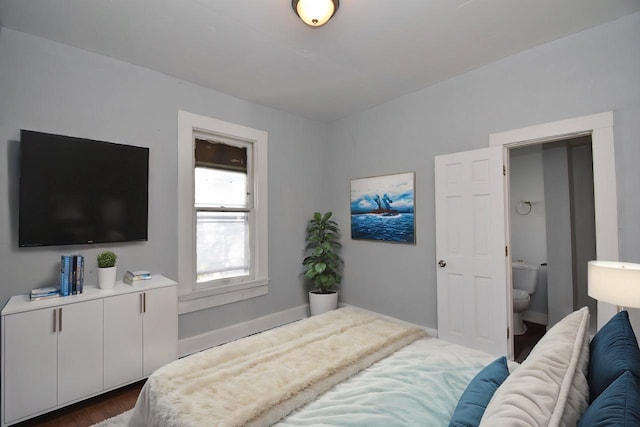 bedroom featuring dark hardwood / wood-style floors and ensuite bath