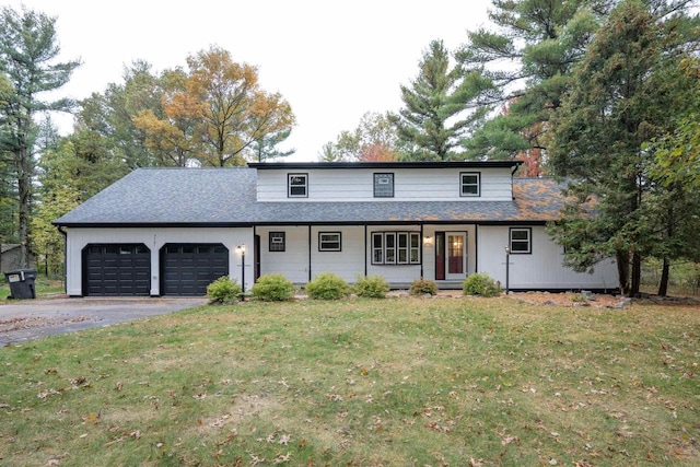 front of property featuring a front lawn, covered porch, and a garage