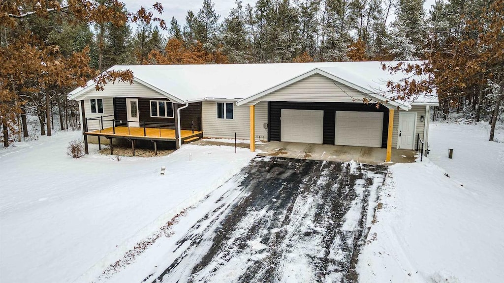 ranch-style house with a garage and a wooden deck