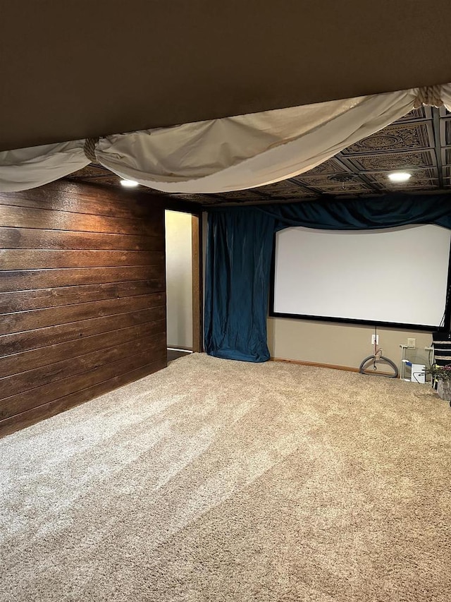 carpeted home theater room with wooden walls