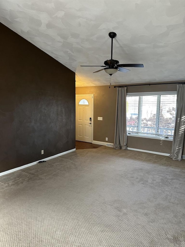 carpeted spare room with ceiling fan