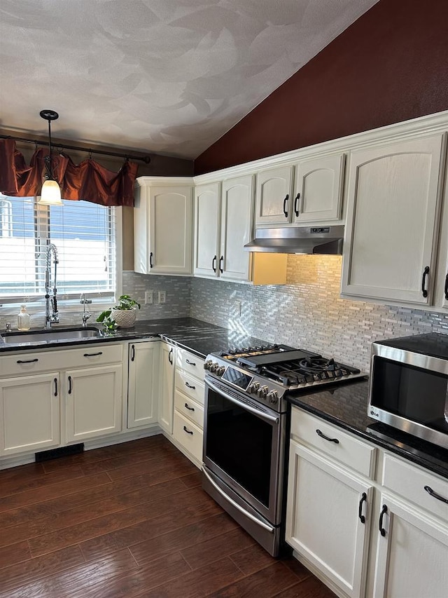 kitchen featuring white cabinets, sink, stainless steel appliances, and vaulted ceiling