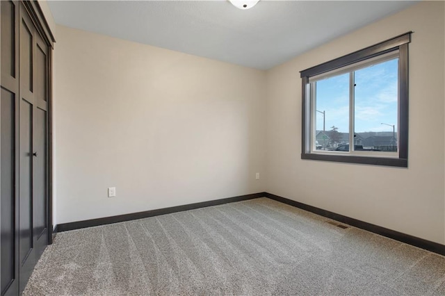 unfurnished bedroom with baseboards, visible vents, and light carpet