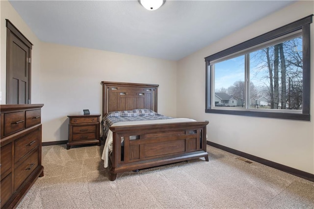 bedroom with light carpet, visible vents, and baseboards