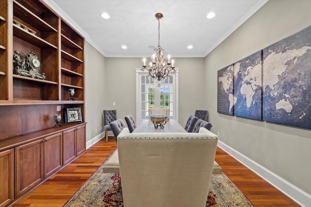 dining room with a notable chandelier, dark hardwood / wood-style flooring, and ornamental molding