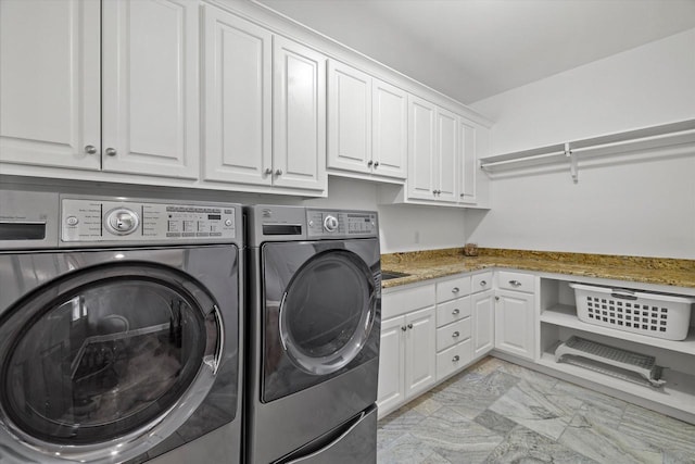 laundry room with washer and clothes dryer and cabinets