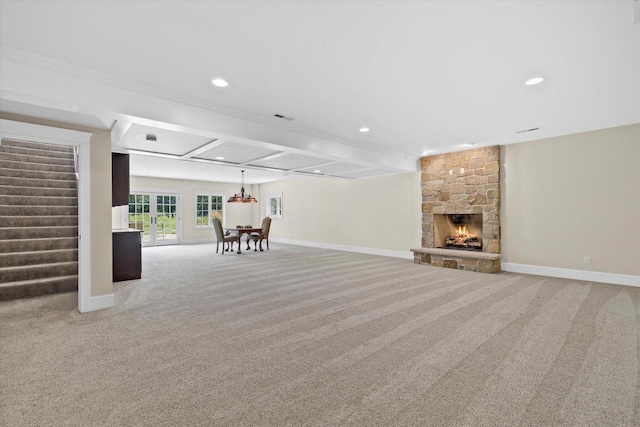 unfurnished living room featuring beam ceiling, crown molding, carpet floors, and a fireplace