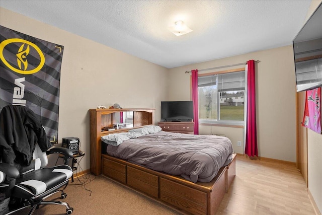 bedroom with light hardwood / wood-style flooring and a textured ceiling