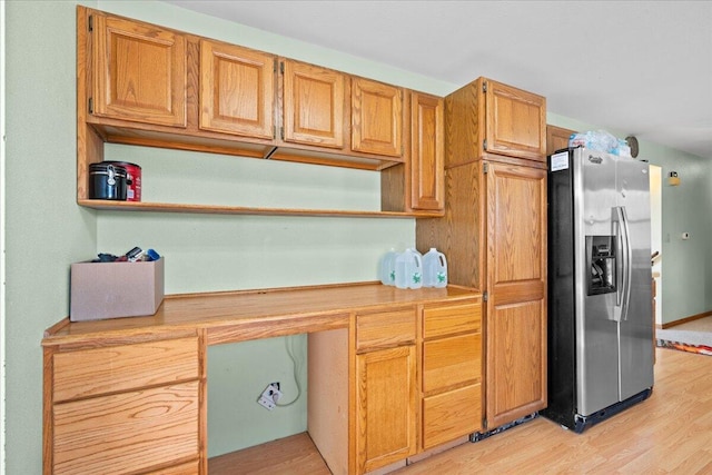 kitchen featuring stainless steel fridge with ice dispenser and light hardwood / wood-style flooring