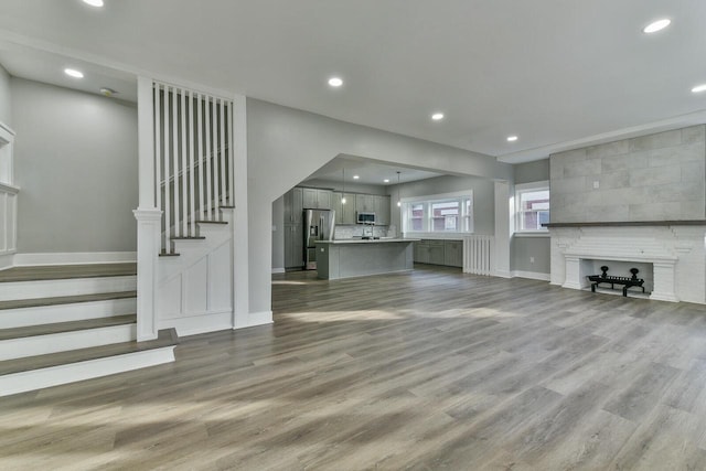 unfurnished living room with a tile fireplace and hardwood / wood-style floors