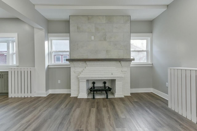 unfurnished living room with a fireplace, hardwood / wood-style floors, and radiator