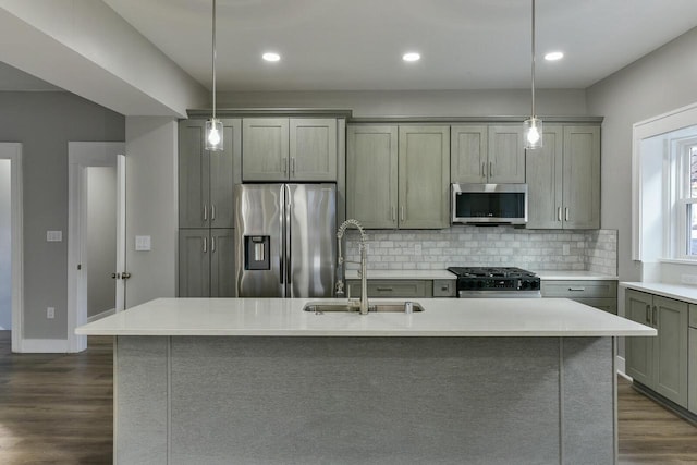 kitchen featuring appliances with stainless steel finishes, a kitchen island with sink, and pendant lighting