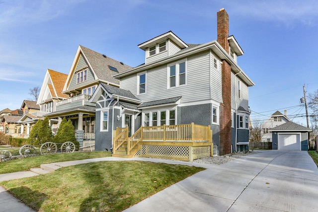 front of property with a garage, an outdoor structure, and a front yard