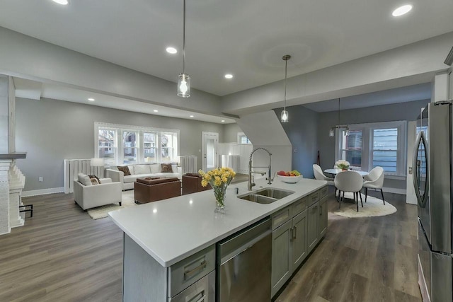 kitchen with hanging light fixtures, sink, an island with sink, and appliances with stainless steel finishes