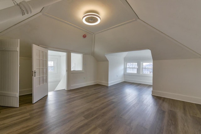 bonus room with dark hardwood / wood-style flooring and vaulted ceiling