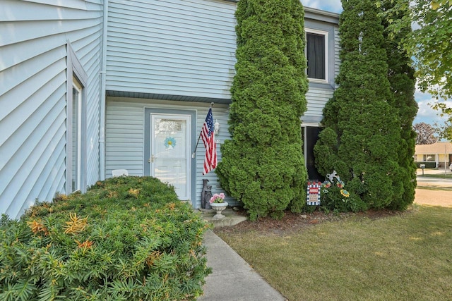 property entrance featuring a lawn