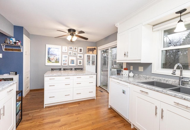 kitchen with dishwasher, sink, pendant lighting, light hardwood / wood-style floors, and white cabinets