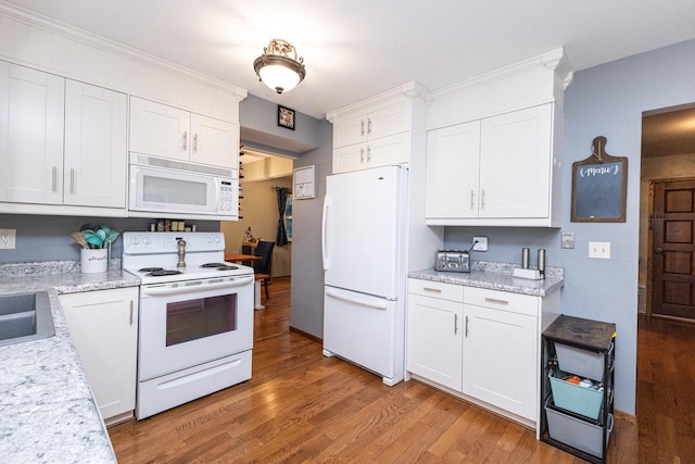 kitchen with white appliances, wood-type flooring, sink, light stone countertops, and white cabinetry