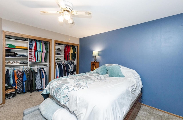 carpeted bedroom with two closets and ceiling fan