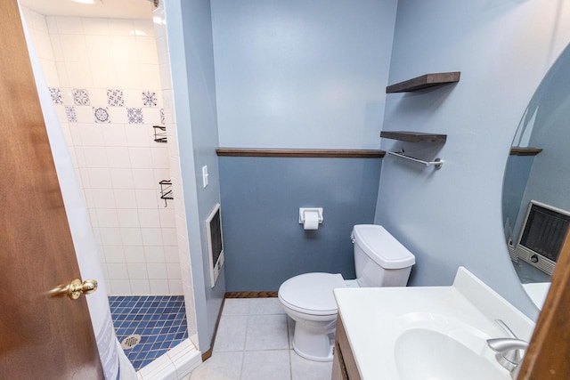 bathroom featuring toilet, tile patterned flooring, vanity, and tiled shower