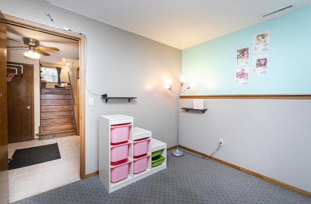 interior space with ceiling fan and light colored carpet