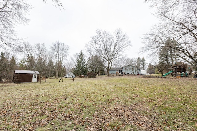 view of yard featuring a playground and a shed