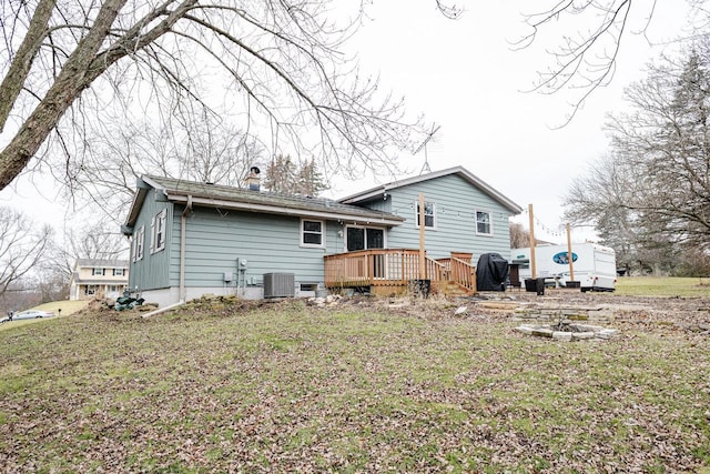 back of property featuring central AC unit, a deck, and a yard