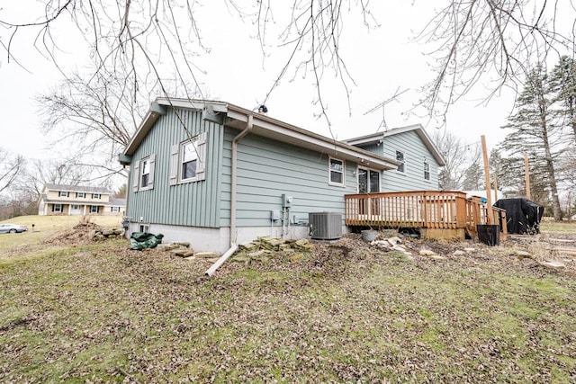 rear view of property with central air condition unit and a wooden deck