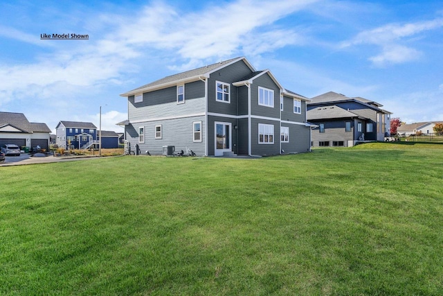 back of house with central AC unit and a lawn