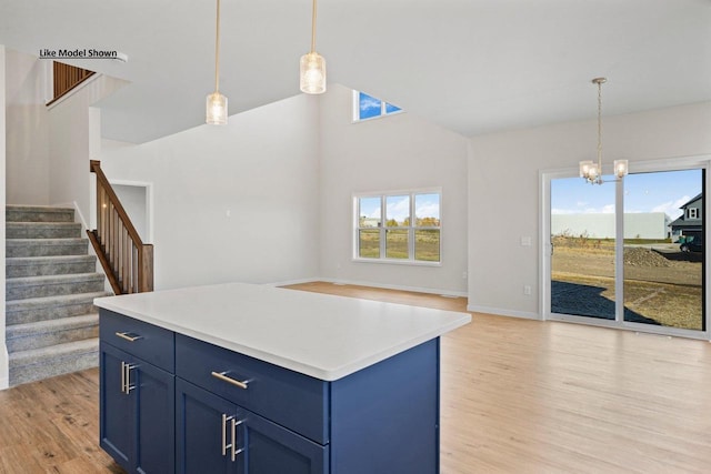 kitchen featuring decorative light fixtures, a center island, and blue cabinetry