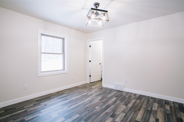 spare room featuring dark wood-type flooring