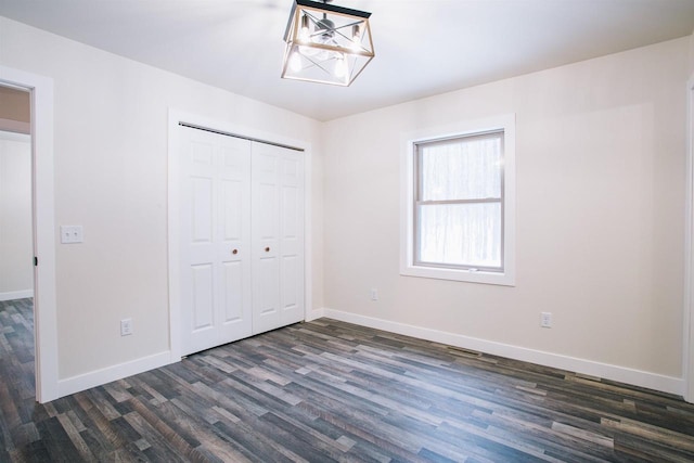 unfurnished bedroom with a closet and dark wood-type flooring