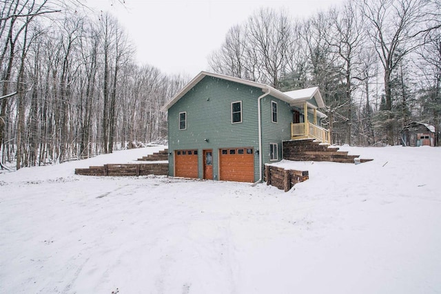 snow covered property with a garage