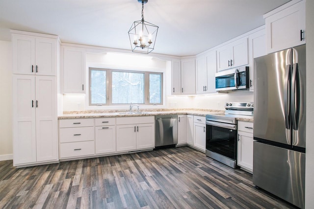 kitchen with decorative light fixtures, white cabinetry, stainless steel appliances, and dark wood-type flooring